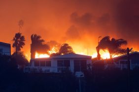 Flames from a brush fire pushed by gusting Santa Ana winds approach homes on January 7, 2025 in Pacific Palisades, Los Angeles, California. A fire in the Pacific Palisades area of Los Angeles has forced some residents to evacuate amid "life-threatening and destructive" winds.